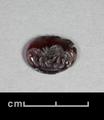Elliptical seal made of intaglio garnet. The design shows a lion on the right which is just about to attack a dog (?) depicted on the left of the seal. The edges are chipped.