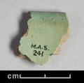 Rim-sherd of a vessel. Made of grey clay with a green glaze on both sides.