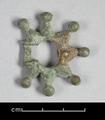Bronze belt buckle in the shape of a star with seven spikes. The tongue of the buckle is missing.;