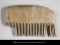 Wooden comb with a slightly arched top. Some of the widely spaced teeth have broken off.;