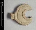 Fragment of wall-decoration made of light grey clay with traces of red paint. The crescent-shaped object is decorated with two incised lines.