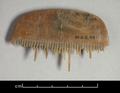 Fragmentary horn comb with an arched top. Most of the teeth have broken off.
