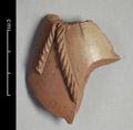 Fragment of a clay vessel with a decoration imitating a twisted rope. The material used is red clay that shows traces of a white slip. The inside of the sherd is smooth and does not show the pattern characteristic for wheel-thrown pottery. Hence the vessel was most likely made using pottery-mould.