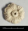 Stucco ornament in the shape of a lotus with a raised seed cup and six petals.