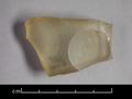 Fragment of a glass vessel. The glass is yellowish-white and translucent, the outside decorated with hollow-ground circles.