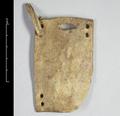 Single scale of armour made of carved leather. One corner of the originally rectangular object is broken off. In each of the remaining three corners, two holes have been drilled. Additionally, a larger hole was cut into one of the short sides. One of the leather strips with which the pieces were originally bound together is still in place.;