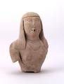 Fragmentary clay figure of a woman. Only head and upper body remain. The woman is shown with long hair falling to her shoulders which is cut into a straight fringe. Her upper body is bare except for the two necklaces she is wearing. A hole through the mouth shows that the figure might have been a vessel, for instance an oil dripper.  The figure was mould-made using red clay and covered with a white slip before being fired. Details such the eyes and the strands of here were rendered using incised lines.;