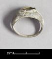 Silver ring with a round bezel on top. The round stone it would have originally contained is now missing.