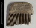 Fine-toothed wooden comb with an arched top. Some of the teeth have  broken off.