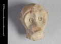 Fragmentary clay figurine of a monkey. Only the head remains. Details such as the eyes and the fur were rendered using incised lines. The object was covered with a white slip before being fired.;