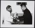 Photograph of Chang Shuhong presenting an album of photographs and a manuscript facsimile to Raghu Vira at the Dunhuang Institute taken in 1955.