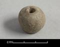 Round, slightly irregularly shaped loom-weight with a flattened base. Made of fired clay.