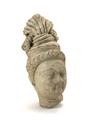 Fragmentary stucco figure. This is the head of a male person with a serene facial expression, probably a Bodhisattva. The hair is drawn loosely back under a broad band circling the top of the head twice and fastened into a fan-shaped topknot. The hair comes out from the side of the topknot over the right ear where it is twisted and caried back through the turban. The end hangs loosely over the left ear. Traces of a white slip can still be seen.;