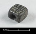 Rectangular seal made of lignite. The object is pierced horizontally and bears an inscription consisting of four Chinese characters on one side.