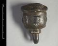Cast bronze ornament in the shape of a human head with two faces. It has a loop for suspension under the neck.;
