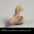 Fragmentary clay figure of a bird. Only the head of the bird with a long beak and a crest of feathers remains. Details are rendered using incised lines.