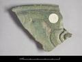 Rimsherd of a vessel. The outside is decorated with an incised floral pattern and was then covered with a green glaze.