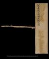 Fragmentary title page of Dunhuang manuscript scroll with stave and remains of silk braid.